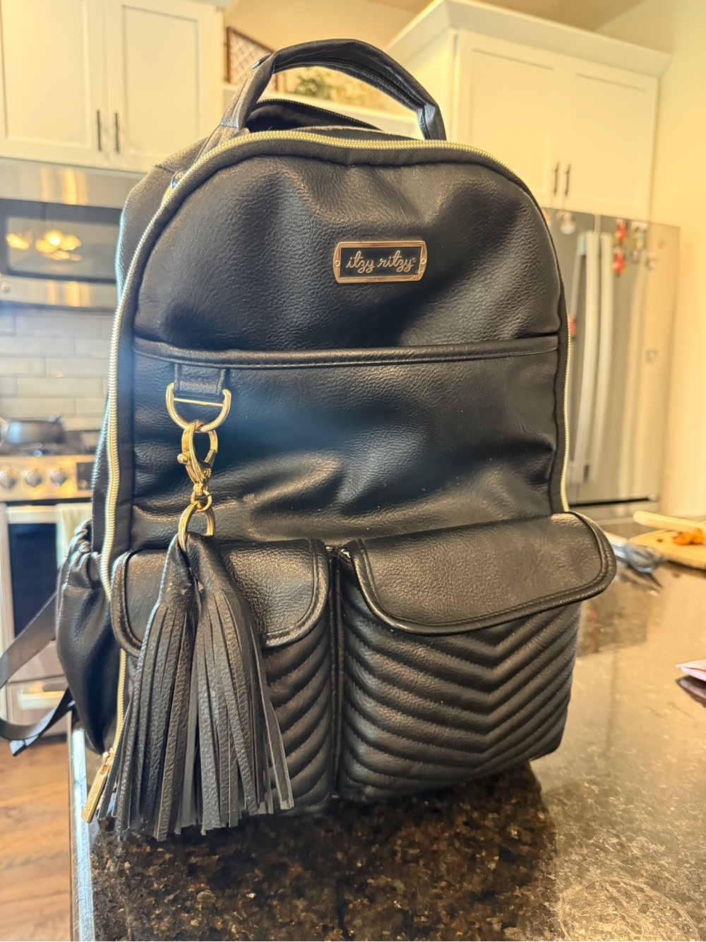 Itzy Ritzy Black Quilted Faux Leather Diaper Backpack with Tassel Charm
